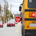 school bus with stop sign flashing on the street