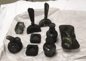Before image of glass items covered in soot.